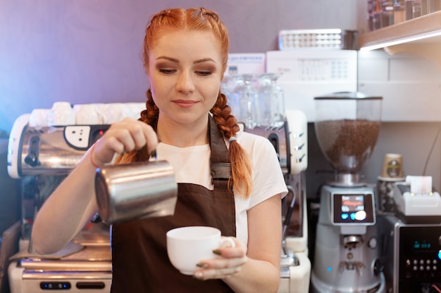Das rothaarige Barista-Mädchen braut Kaffee aus der Türkei im Café