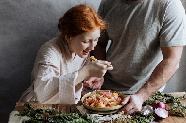 Das rothaarige Mädchen probiert Kartoffelsalat, den sie mit ihrem Vater gemacht hat.