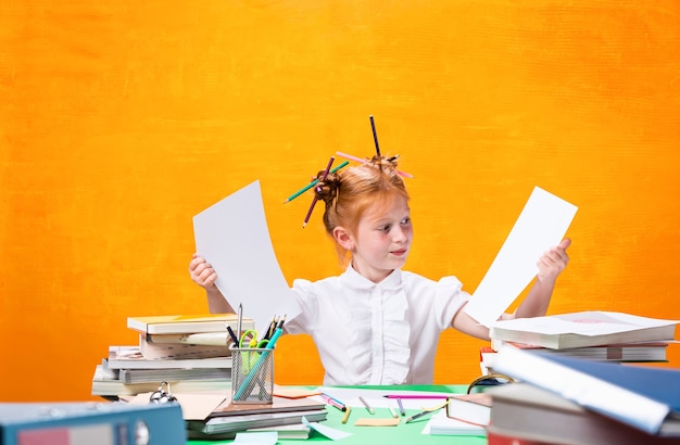 Das rothaarige Teenie-Mädchen mit vielen Büchern zu Hause. Studioaufnahme