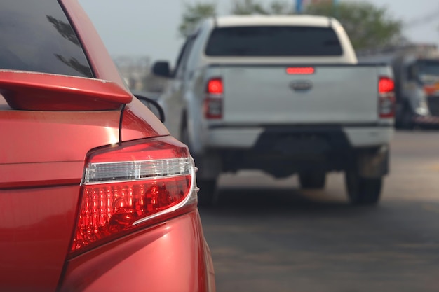 Das Rücklicht eines bremsenden Autos auf der Straße und ein verschwommenes Bild hinter einem anderen Auto