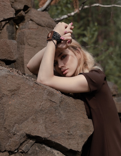 Das schöne Mädchen in einem Kleid auf den Felsen