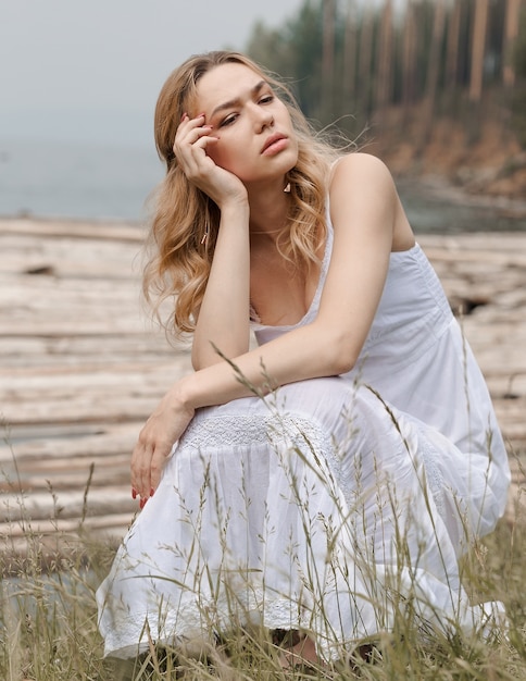 Das schöne Mädchen in einem Kleid auf den Felsen