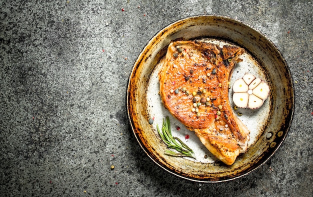 Das Schweinesteak mit Gewürzen. Auf rustikalem Hintergrund.