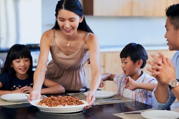 Das sieht köstlich aus Mom Shot von einer Familie, die zu Hause zusammen eine Mahlzeit genießt