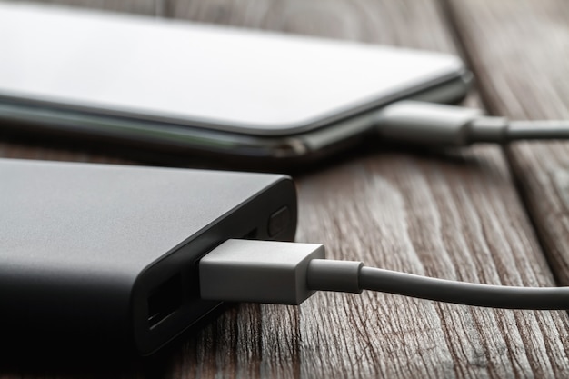 Das Smartphone wird über ein Kabel von einer externen Powerbank aufgeladen