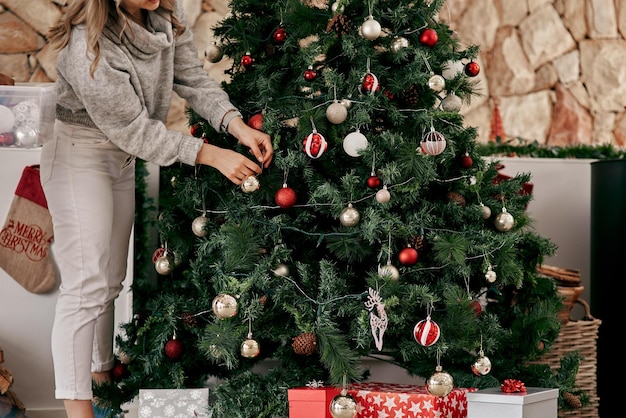 Das sollte funktionieren. Schnappschuss einer nicht wiederzuerkennenden Frau, die tagsüber zu Hause Dekorationen an einem Weihnachtsbaum anbringt