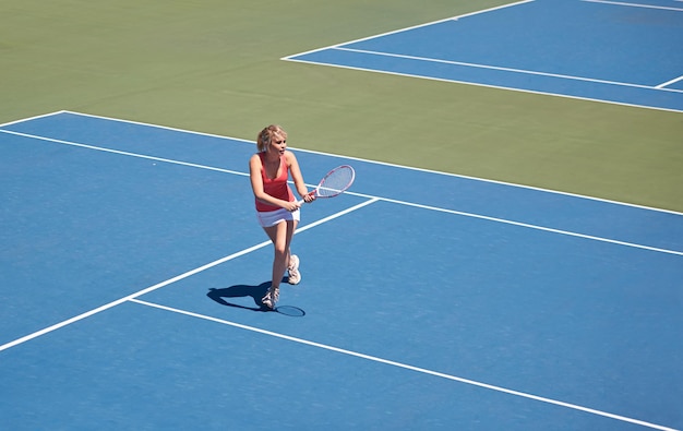 Das Spiel gewinnen Frau, die Tennis auf dem Tennisplatz spielt