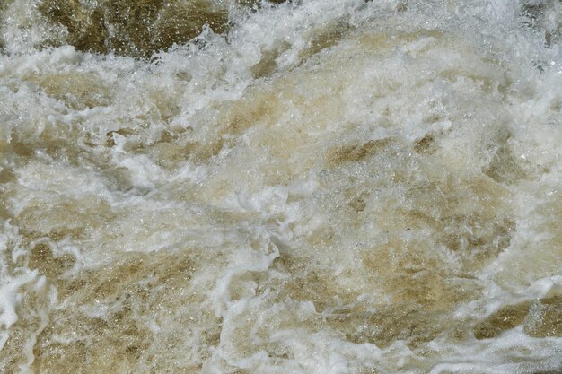 Das sprudelnde klare kalte Wasser des Wasserfalls in Nahaufnahme Der Gebirgsfluss stürzt über Steine