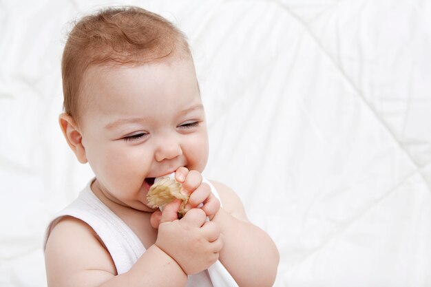 Das süße Baby lacht fröhlich und hält einen Kamm im Mund. Speicherplatz kopieren