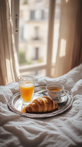Das Tablett mit einem Glas frisch gepressten Orangensaft, einer Tasse aromatischem heißen Kaffee und einem Croissant