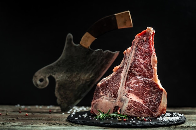 Das Tbone- oder Porterhouse-Steak vom Rind, das aus dem kurzen Lendensteak geschnitten wird, umfasst T-förmigen Knochen mit Fleisch auf jeder Seite. Porterhouse-Steaks werden aus dem hinteren Ende des kurzen Lendensteaks geschnitten