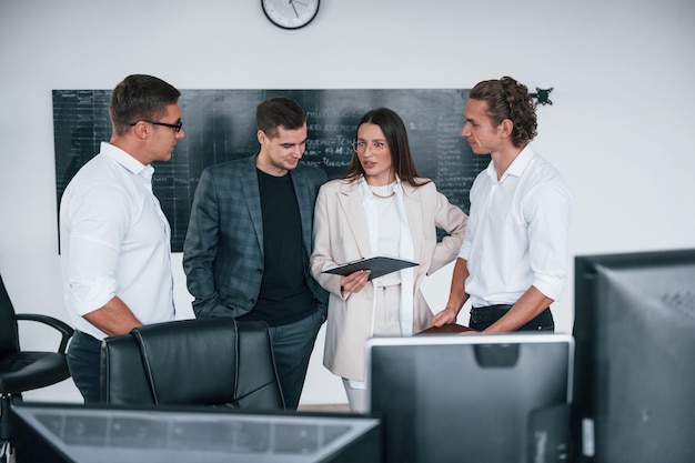 Das Team von Börsenmaklern arbeitet in einem modernen Büro in der Nähe der Tafel