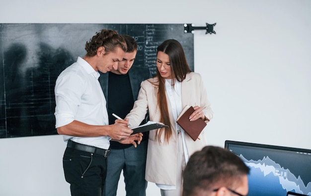 Das Team von Börsenmaklern arbeitet in einem modernen Büro mit vielen Bildschirmen