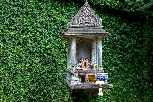 Das thailändische Geisthaus mit Ficus pumila Hintergrund