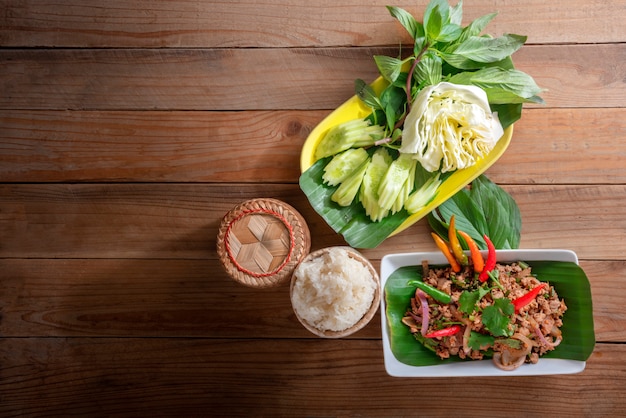 Das thailändische Lebensmittel, das laab MOO genannt wird, essen mit klebrigem Reis im klebrigen Reis Kratib
