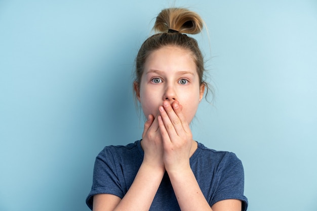 Das verängstigte Teenager-Mädchen bedeckt ihren Mund mit den Händen