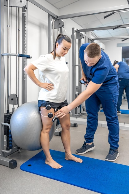 Das Verfahren der Myostimulation an den Beinen einer Frau