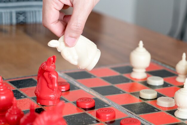 Das weiße Schach auf Frauenhand kämpft mit Rot