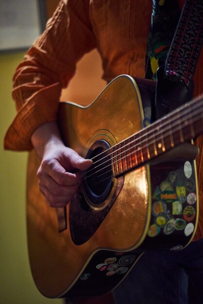 Das wirkliche Leben spielt. Schließen Sie oben von den männlichen starken Händen, die Gitarre spielen und verbessern