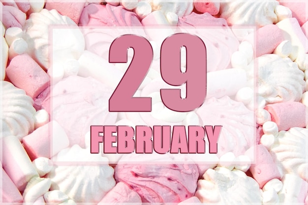 Data do calendário no fundo de marshmallows brancos e rosa 29 de fevereiro é o vigésimo nono dia do mês