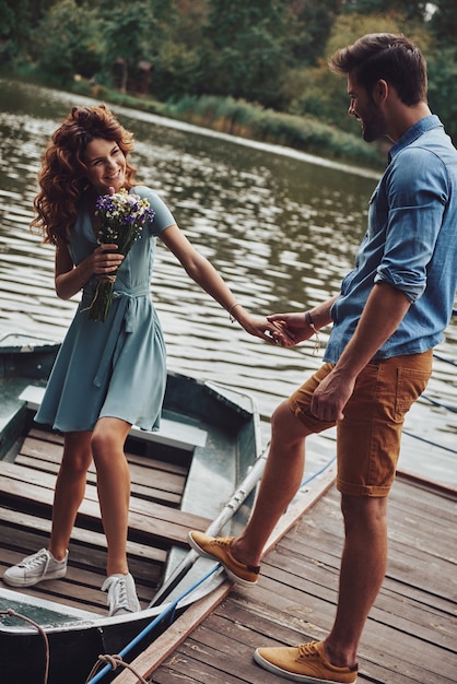 Data Romantica. Jovem casal feliz se preparando para remar um barco enquanto desfruta de seu encontro ao ar livre