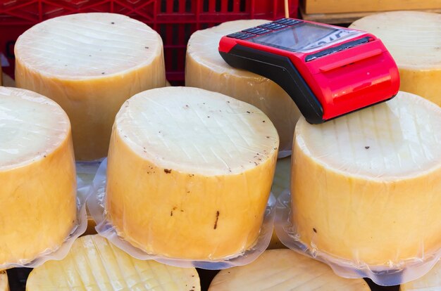 Un datáfono encima de las porciones de puro queso de oveja artesano para recoger y pagar evitando el contacto