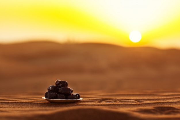 Datas em um belo prato no deserto em um belo pôr do sol, simbolizando o Ramadã