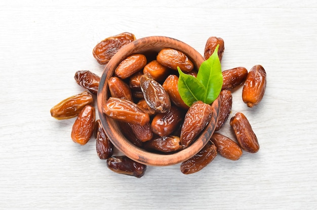 Dates dulces secos sobre un fondo de madera blanca