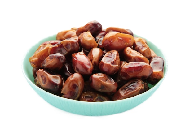Dates frescos en un cuenco de menta aislados sobre un fondo blanco