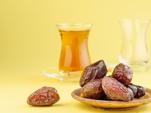 Datiert mit schwarzem Tee auf gelbem Grund. Traditionelles Iftar-Essen im Ramadan.