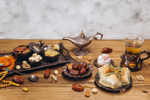 Dátiles secos y té en una mesa de madera Platos tradicionales árabes ollas y dátiles frutas Ramadán Kareem Eid mubarak concepto Copiar espacio