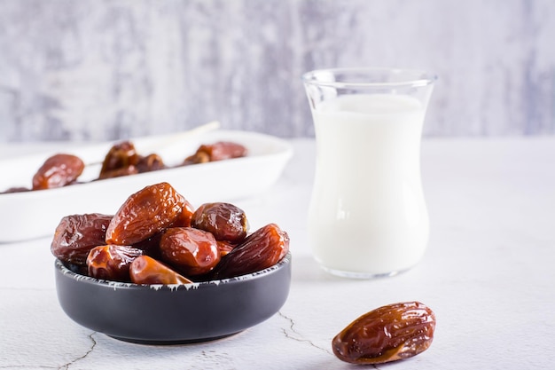 Datteln in einer Schüssel und ein Glas Milch auf dem Tisch Essen für den heiligen Monat Ramadan