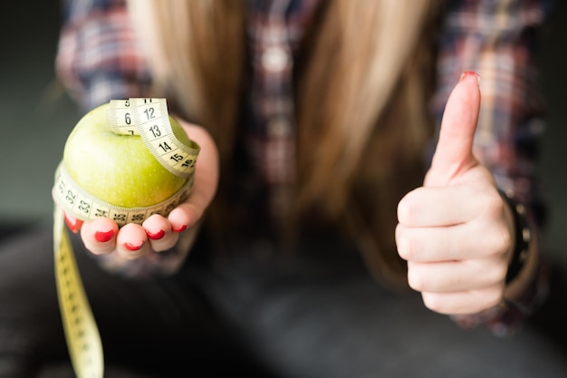 Foto daumen hoch für gesunde ernährung und ausgewogenes essen von apfelfrüchten für einen schlanken und fitten körper und gewichtsverlust