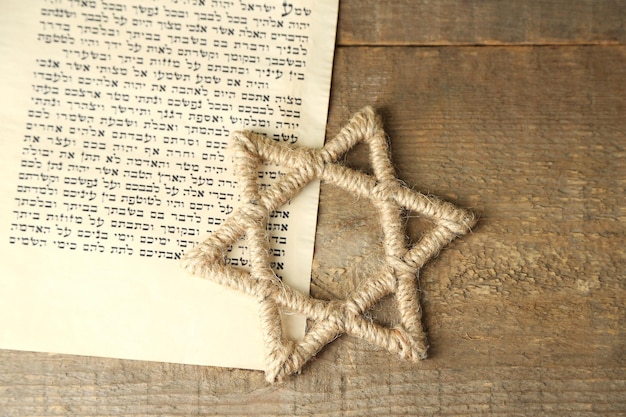 Davidsstern und eine Seite aus dem Buch Genesis auf Holzgrund