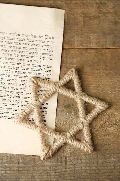 Davidstern und Seite des Genesis-Buches auf Holzhintergrund