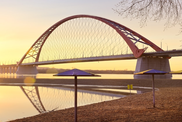 Dawn of the Bugrinsky Bridge Uma praia deserta na primavera uma moderna ponte rodoviária arqueada