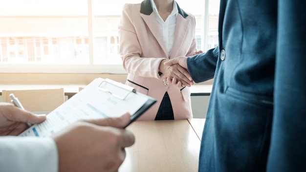 De equipe de negócios bem sucedida apertando as mãos no escritório, conceito de entrevista de emprego