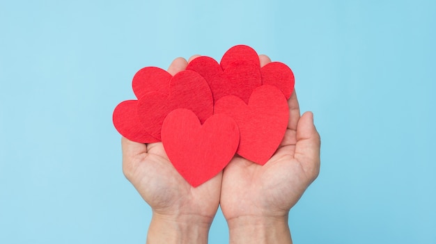 Dé llevar a cabo un corazón rojo de la tela en un fondo azul.