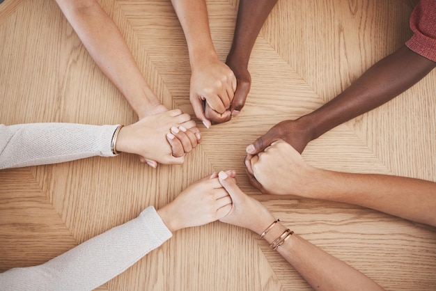 Foto de mãos dadas fé e oração grupo de apoio de pessoas ou amigos com esperança religião e confiança ou respeito juntos ajudando e amando a comunidade com compromisso solidariedade e trabalho em equipe de cima