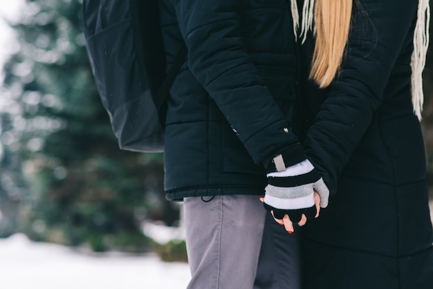 Dê-me seu braço. retrato recortado de um jovem casal feliz, de mãos dadas e aproveitando o momento. pessoas no conceito de floresta de inverno