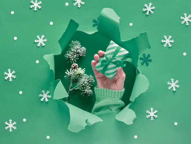 De papel verde plana leigos com flocos de neve e buraco rasgado no meio