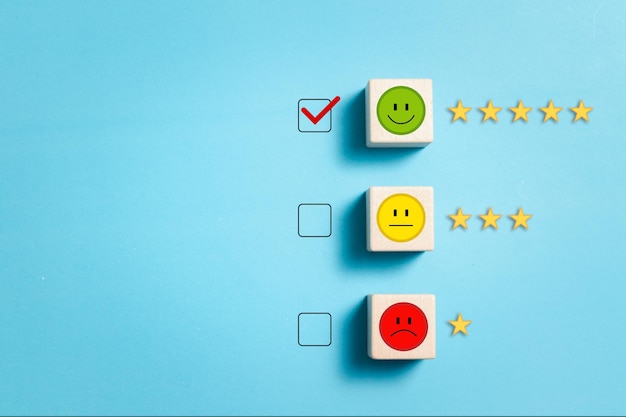 Dê satisfação com um rosto sorridente de 5 estrelas em um bloco de madeira Classificação de experiência de satisfação e avaliações de serviço Conceito de serviço de satisfação do cliente