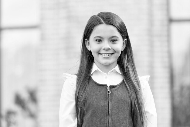 Dê um grande ânimo para o novo ano letivo Aluna feliz ao ar livre Aluna de volta à escola Aluna pequena usa uniforme Educação formal Ensino particular 1º de setembro Dia do conhecimento