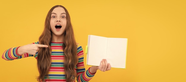 Foto dê uma olhada, leia um livro garota surpreendida aponta o dedo para o livro aberto leia para ter sucesso no espaço de cópia banner de estudante estudante retrato de aluno de escola com espaço de cópia