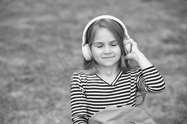 Dê vida à música Criança pequena ouve música com os olhos fechados Menina pequena usa fones de ouvido tocando música Nova tecnologia Vida moderna Diversão e entretenimento Aperte o play e aproveite o espaço da cópia