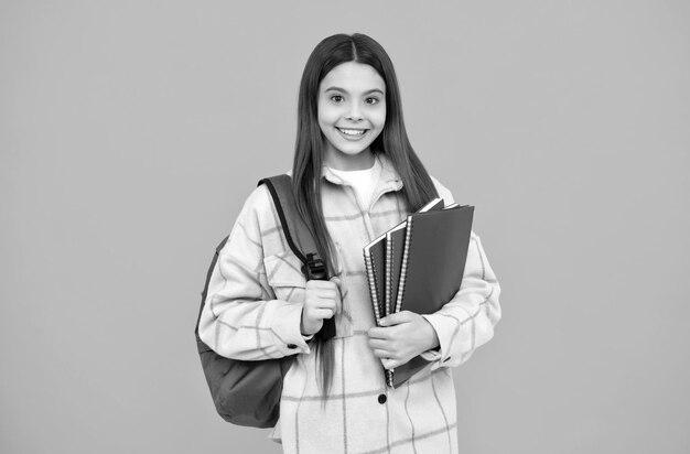 De volta à aula, estudante alegre segura cadernos e livros de volta à escola, adolescente de camisa quadriculada, criança feliz, estilo casual, carrega mochila, criança com bolsa escolar, infância e educação