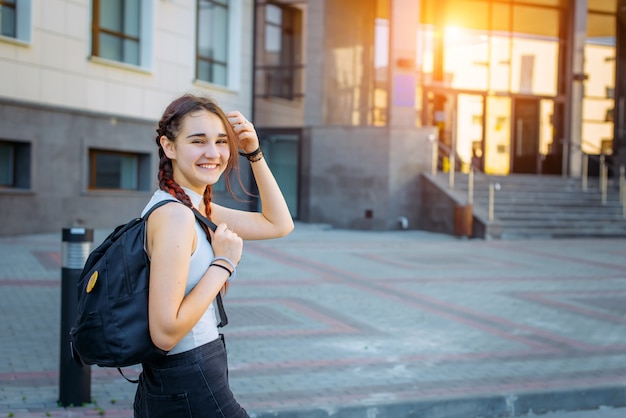 De volta à escola. Abra o retrato de uma adolescente feliz com uma mochila