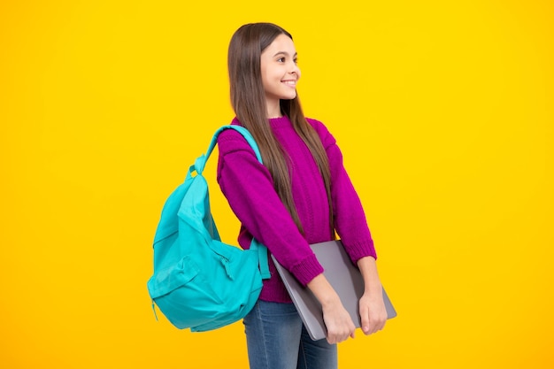 De volta à escola Aluna adolescente segura notebook notebook Crianças em idade escolar em fundo amarelo isolado do estúdio