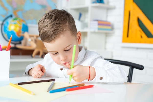 De volta à escola aluno desenhando na mesa criança na sala de aula criança da escola primária