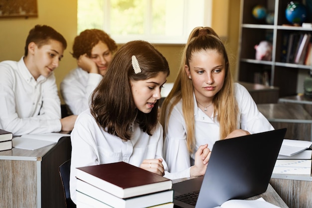 De volta à escola As crianças estudam on-line no laptop e se comunicam com colegas on-line na aula de geografia e discutem diferentes países com o globo